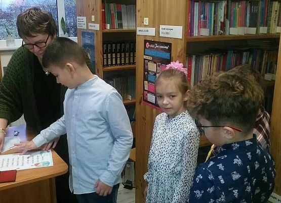 Grafika 5: "W KRÓLESTWIE KSIĄŻEK" - Pasowanie na czytelnika uczniów klasy pierwszej  w bibliotece szkolnej. NPRc 2.0
